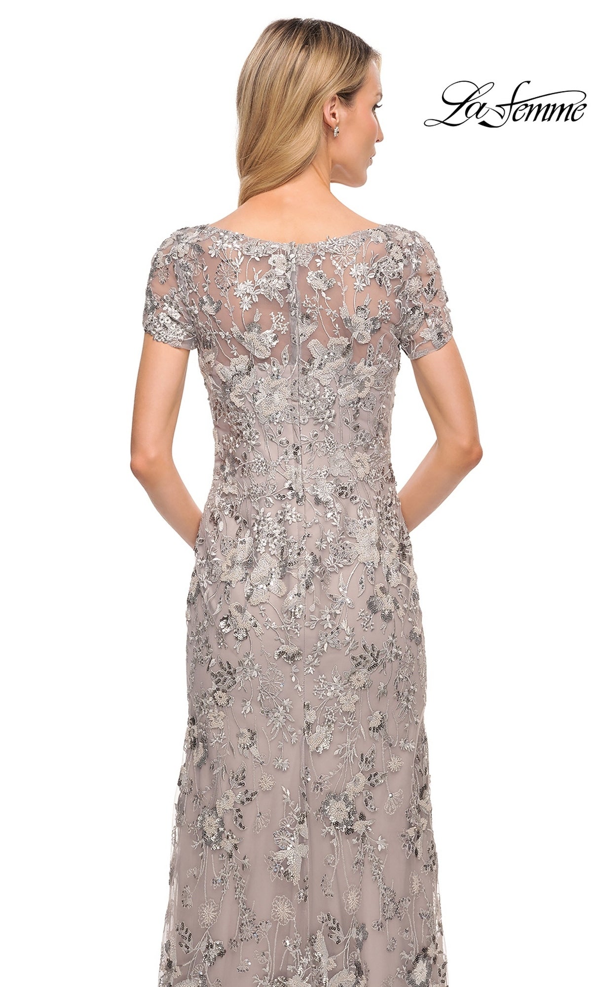 Back view of the Long Formal Dress: La Femme 30053, a floor-length, short-sleeved embroidered sheath evening gown with silver floral embroidery and sequins over a beige base.